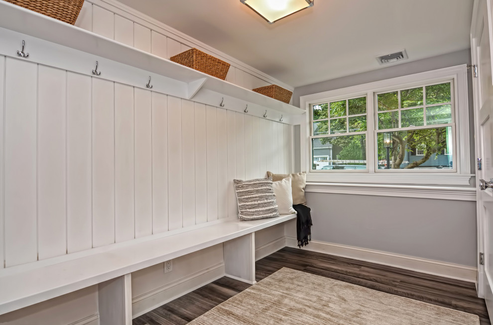 Design ideas for a mid-sized transitional mudroom in Boston with grey walls, laminate floors, a white front door and brown floor.