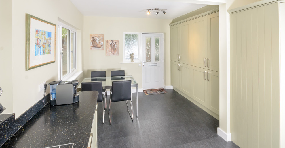 Mid-sized traditional l-shaped eat-in kitchen in Other with an undermount sink, shaker cabinets, light wood cabinets, solid surface benchtops, panelled appliances and no island.