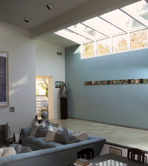 This is an example of an expansive modern loft-style living room in New York with blue walls, marble floors, a standard fireplace and a stone fireplace surround.