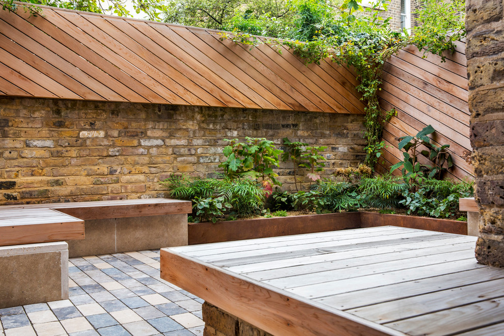 This is an example of a contemporary backyard patio in London with no cover.
