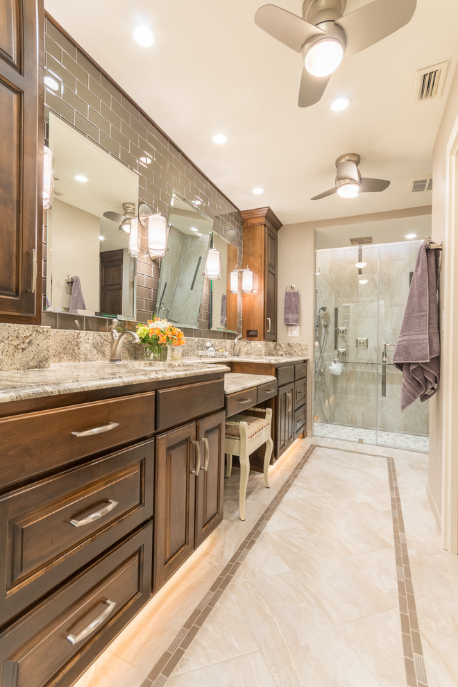 Mid-sized transitional 3/4 gray tile and glass tile porcelain tile walk-in shower photo in Austin with raised-panel cabinets, medium tone wood cabinets, a wall-mount toilet, beige walls, an undermount sink and granite countertops