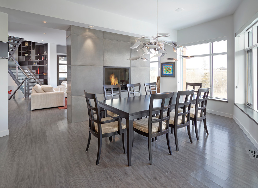 Design ideas for a contemporary dining room in Edmonton with white walls and a two-sided fireplace.