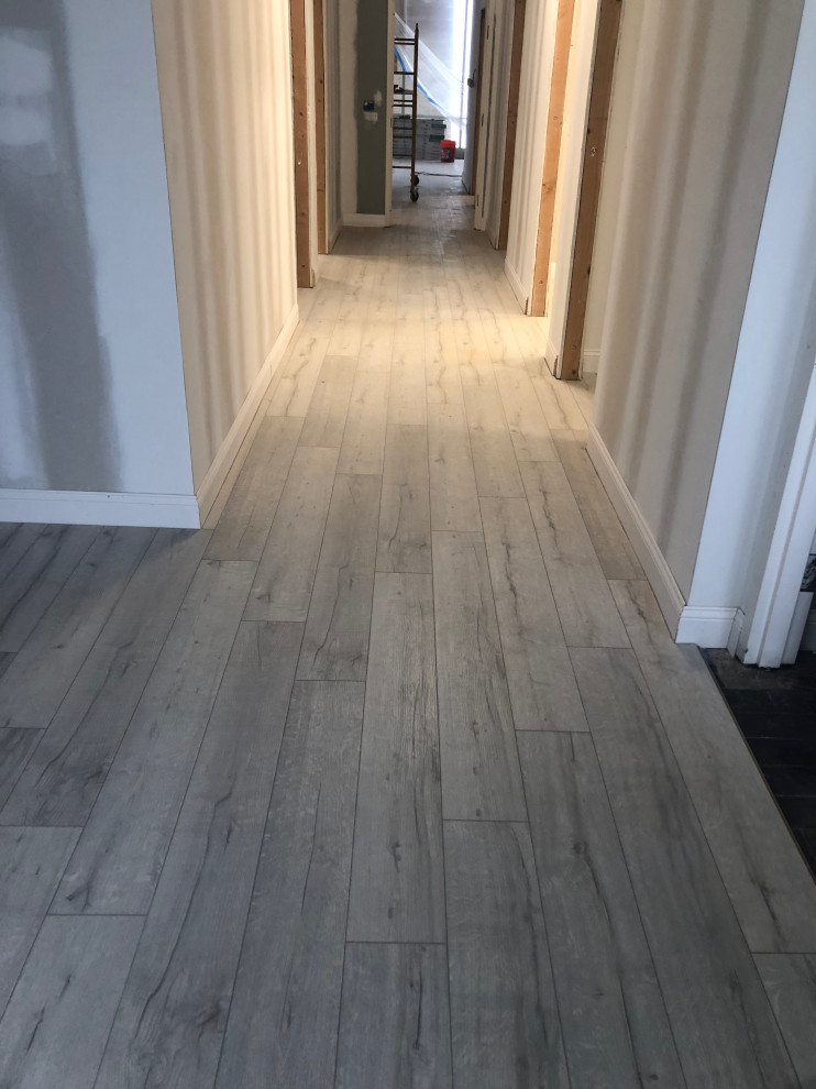 Photo of an expansive hallway in Jacksonville with vinyl floors and grey floor.