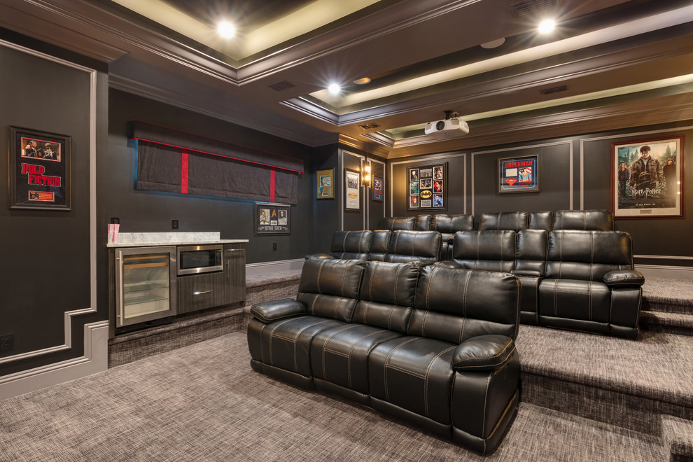 This is an example of a contemporary home theatre in Orlando with black walls, carpet, a projector screen and grey floor.