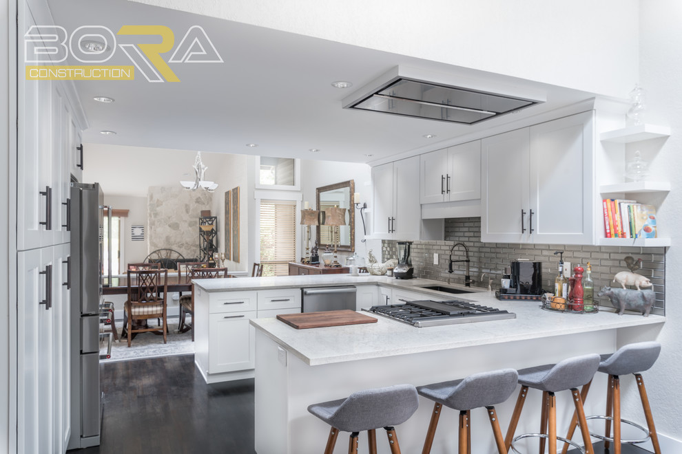 Mid-sized transitional u-shaped dark wood floor and brown floor eat-in kitchen photo with an undermount sink, recessed-panel cabinets, white cabinets, wood countertops, metallic backsplash, ceramic backsplash, stainless steel appliances and a peninsula