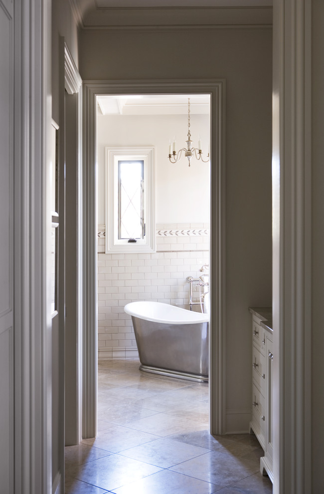 Design ideas for a large transitional master bathroom in Other with shaker cabinets, grey cabinets, limestone benchtops, a freestanding tub, gray tile, subway tile, grey walls and limestone floors.