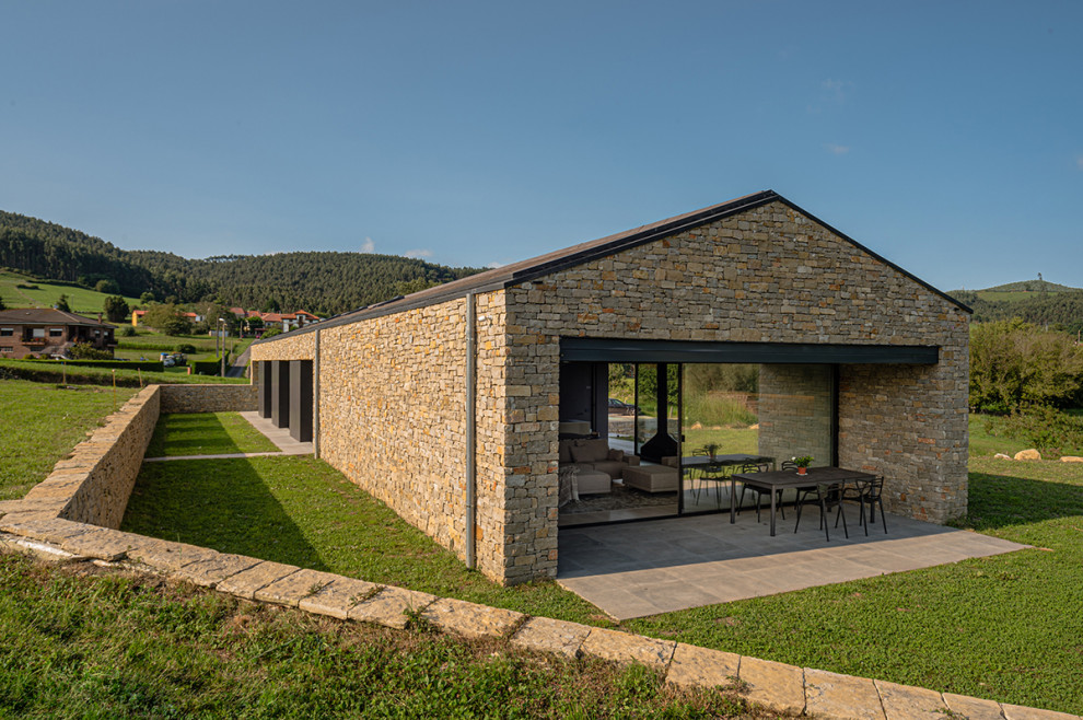 Foto de fachada de casa rural grande de dos plantas con revestimiento de piedra y tejado a dos aguas