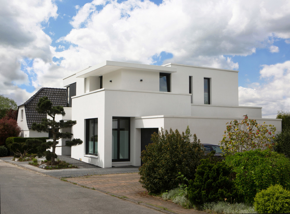 Inspiration for a contemporary two-storey white exterior in Dusseldorf with a flat roof.
