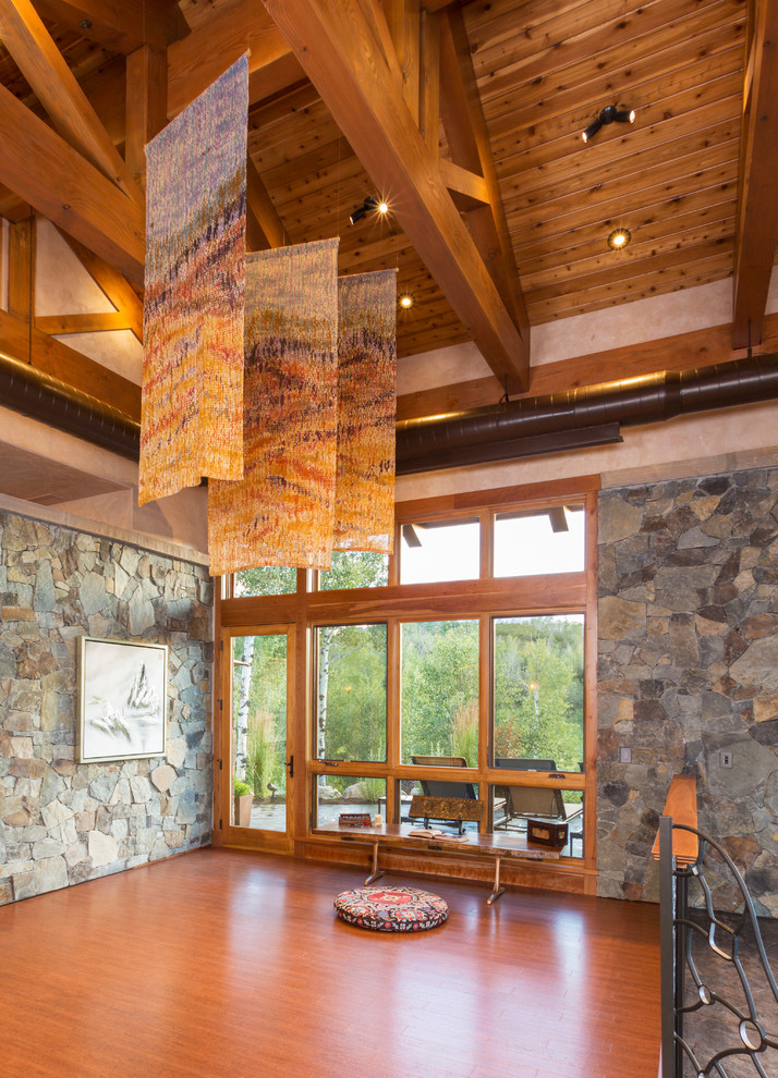 Photo of a mid-sized country home yoga studio in Denver with medium hardwood floors.