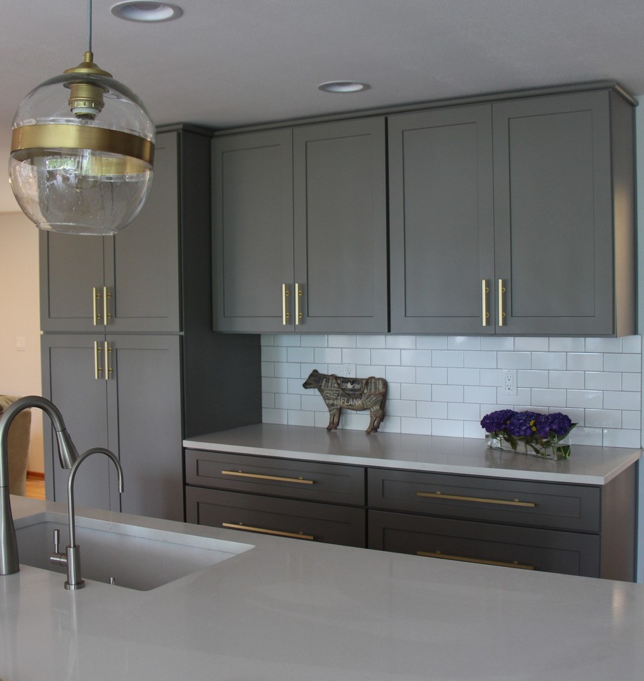 This is an example of a large contemporary u-shaped eat-in kitchen in Seattle with an undermount sink, shaker cabinets, grey cabinets, quartzite benchtops, white splashback, porcelain splashback, stainless steel appliances, porcelain floors and with island.