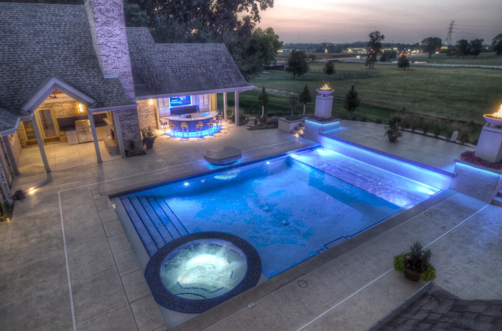 Example of a large transitional backyard concrete paver and rectangular natural hot tub design in Cedar Rapids