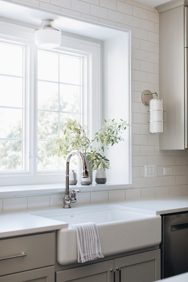 Eat-in kitchen - mid-sized transitional dark wood floor eat-in kitchen idea in Chicago with a farmhouse sink, shaker cabinets, gray cabinets, quartz countertops, white backsplash, ceramic backsplash, paneled appliances, an island and white countertops