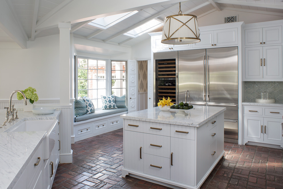 Inspiration for a large traditional l-shaped separate kitchen in Los Angeles with a farmhouse sink, beaded inset cabinets, white cabinets, marble benchtops, green splashback, ceramic splashback, stainless steel appliances, brick floors, with island, red floor and white benchtop.