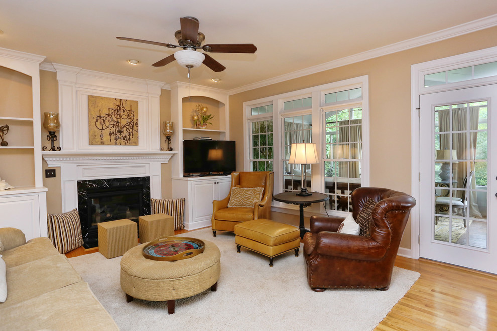 Mid-sized transitional open concept family room in Raleigh with beige walls, medium hardwood floors, a standard fireplace, a wood fireplace surround, a corner tv and brown floor.