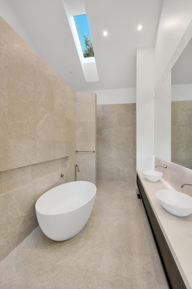 Inredning av ett modernt mycket stort vit vitt en-suite badrum, med luckor med infälld panel, skåp i mörkt trä, ett fristående badkar, en öppen dusch, en vägghängd toalettstol, flerfärgad kakel, marmorkakel, flerfärgade väggar, marmorgolv, ett fristående handfat, granitbänkskiva, beiget golv och med dusch som är öppen