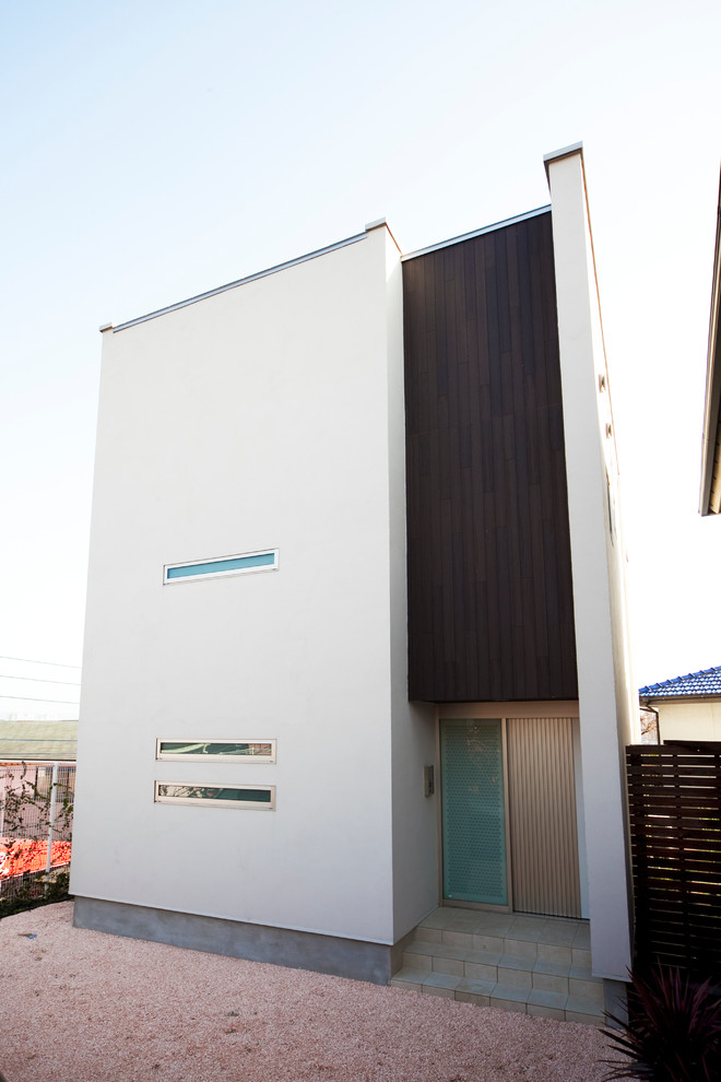 This is an example of a modern two-storey white exterior in Fukuoka with mixed siding and a flat roof.