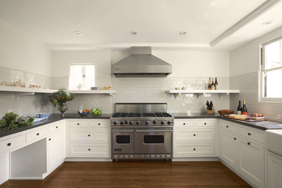This is an example of a traditional kitchen in Los Angeles with stainless steel appliances, recessed-panel cabinets, white cabinets, quartz benchtops, white splashback and subway tile splashback.