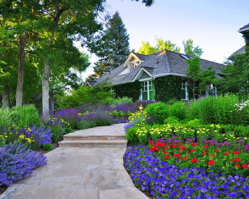 This is an example of a traditional front yard garden for summer in Denver with a garden path.