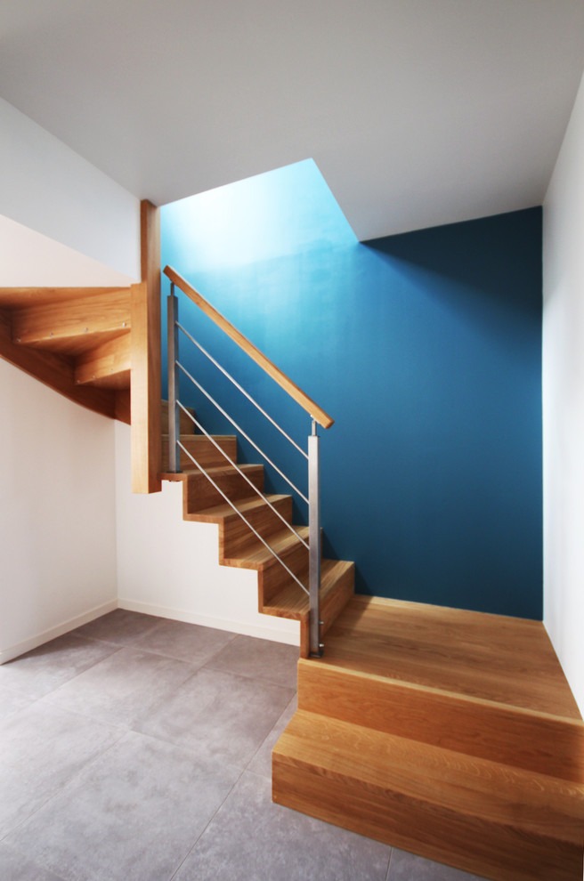 Inspiration for a mid-sized contemporary wood curved staircase in Rennes with wood risers.
