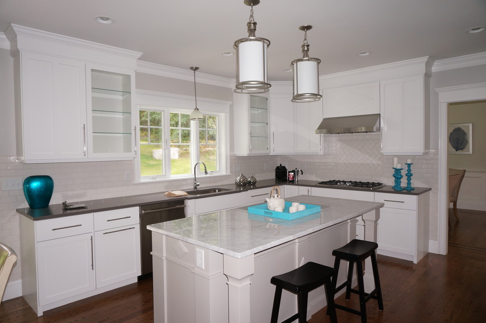 This is an example of a contemporary kitchen in Boston with an undermount sink, recessed-panel cabinets, white cabinets, white splashback, stainless steel appliances and with island.