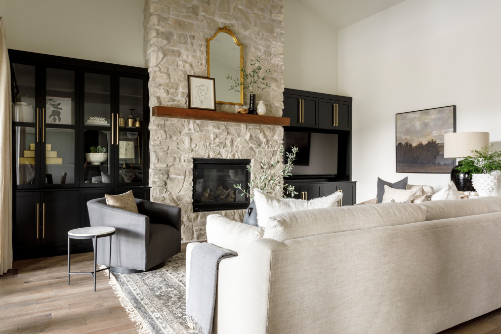 Inspiration for a large classic open plan living room in Boise with white walls, medium hardwood flooring, a standard fireplace, a stone fireplace surround, a wall mounted tv and a vaulted ceiling.