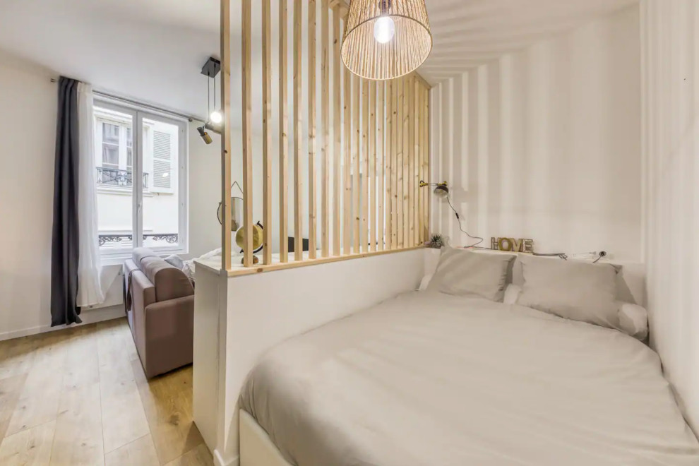 Идея дизайна: большая хозяйская спальня в белых тонах с отделкой деревом в современном стиле с белыми стенами, светлым паркетным полом, стандартным камином, фасадом камина из плитки, бежевым полом и панелями на стенах