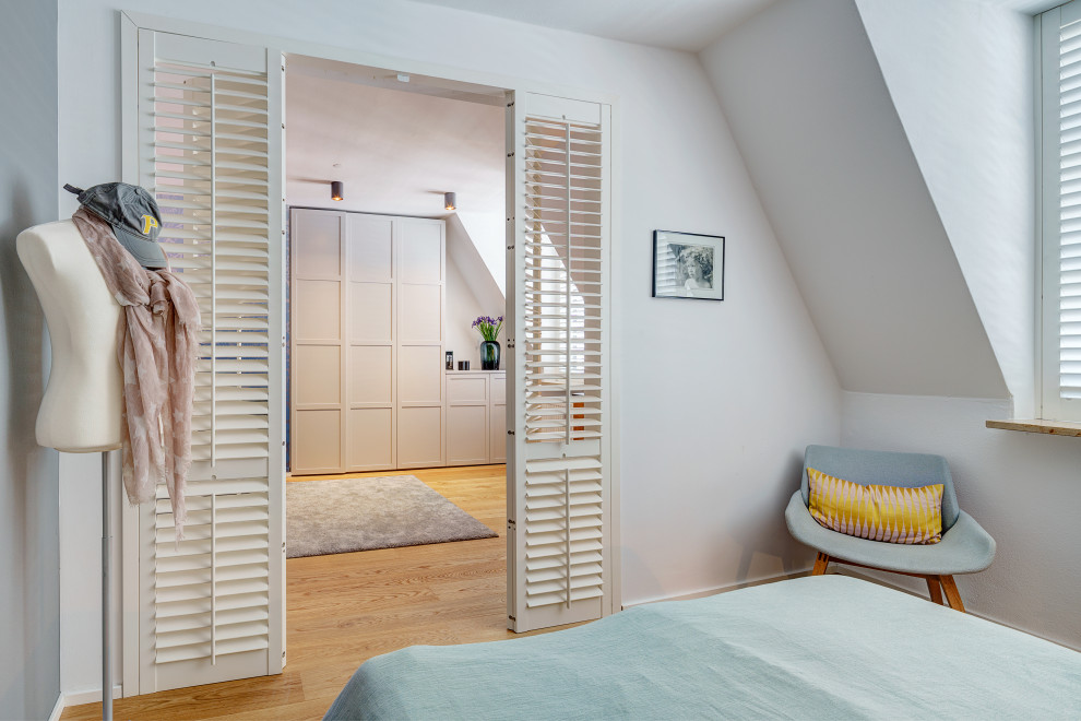 Mittelgroßes Stilmix Hauptschlafzimmer mit grauer Wandfarbe, braunem Holzboden und Tapetenwänden in München