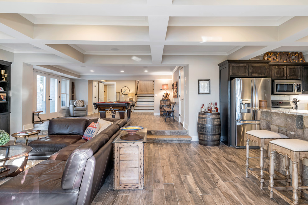 Photo of a mid-sized country basement in Atlanta with a game room, grey walls, dark hardwood floors, a standard fireplace, a stone fireplace surround and brown floor.