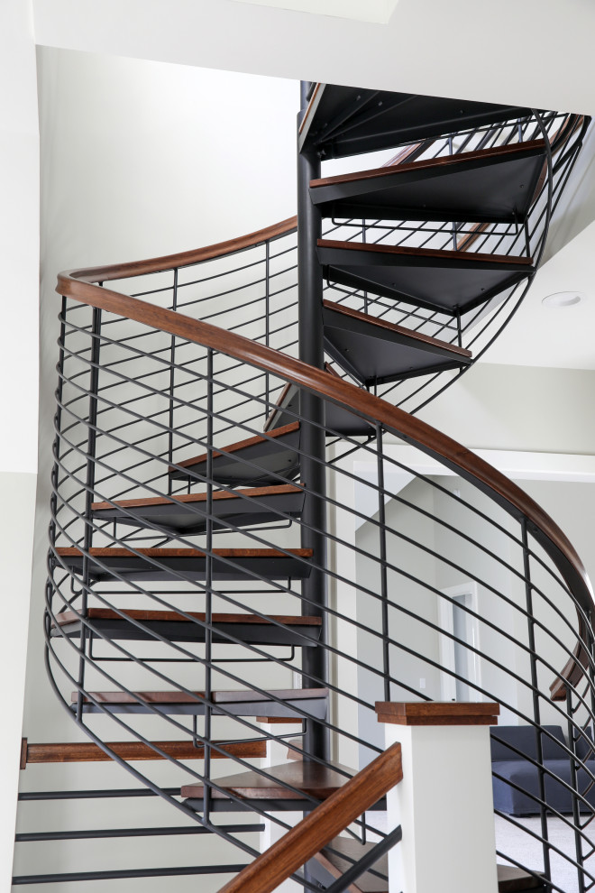 Photo of a small modern wood spiral staircase in Milwaukee with open risers and metal railing.