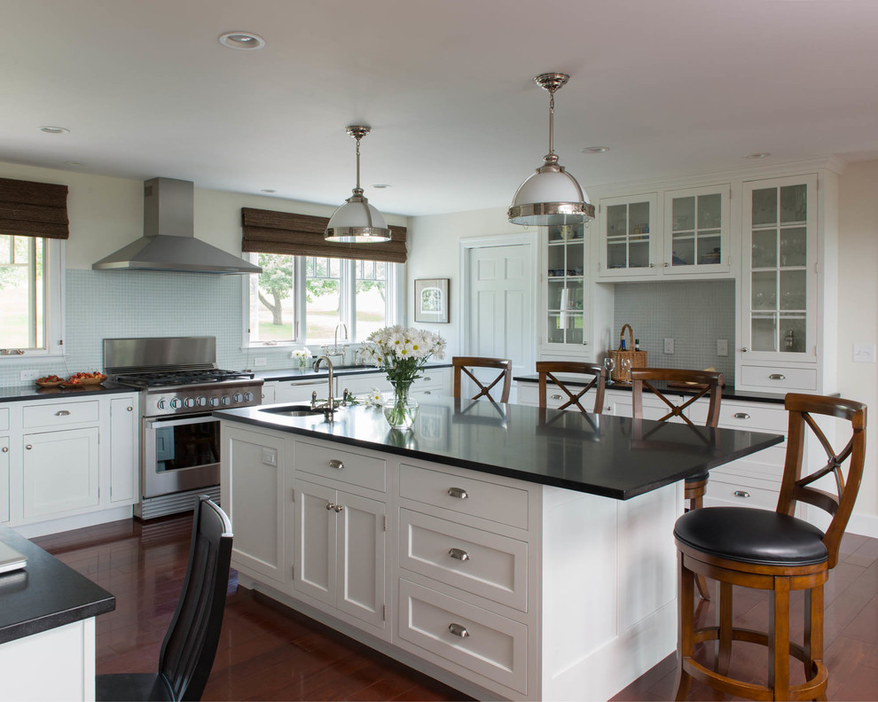 Inspiration for a large transitional u-shaped medium tone wood floor enclosed kitchen remodel with an undermount sink, recessed-panel cabinets, white cabinets, granite countertops, blue backsplash, glass tile backsplash, stainless steel appliances and an island