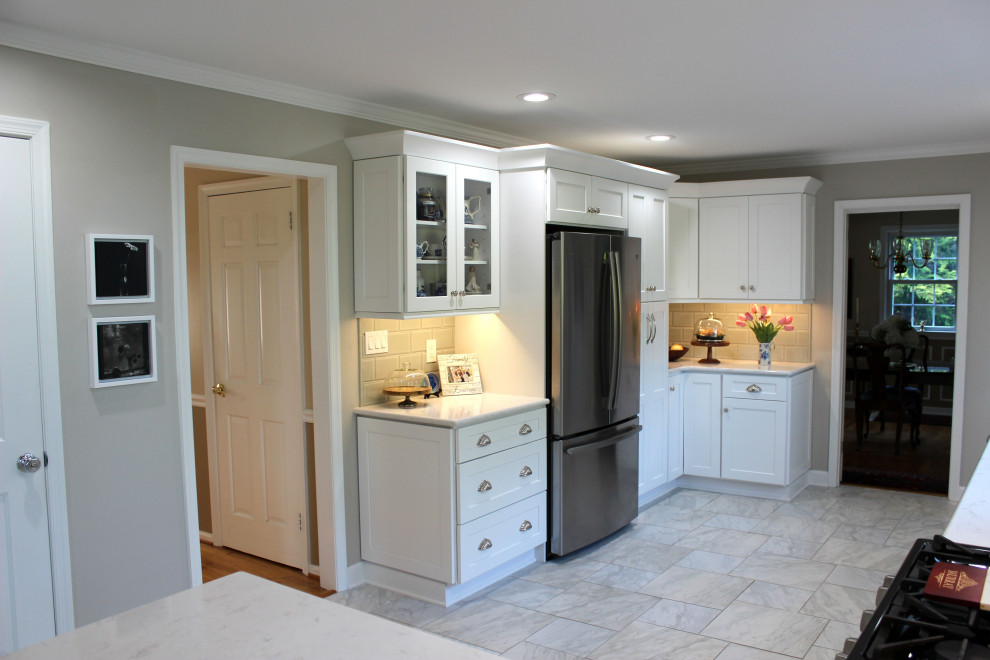 Inspiration for a mid-sized transitional eat-in kitchen in Baltimore with an undermount sink, shaker cabinets, white cabinets, green splashback, mosaic tile splashback, stainless steel appliances, porcelain floors, no island, white floor, white benchtop and vaulted.