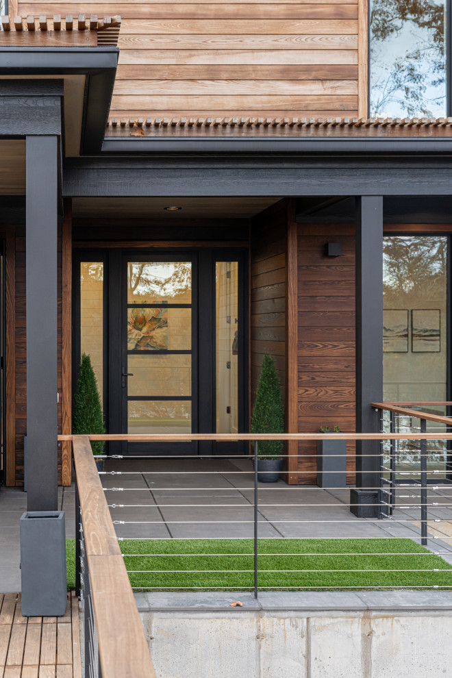 Cette photo montre une petite façade de maison moderne en bois de plain-pied avec un toit en appentis, un toit en shingle et un toit gris.