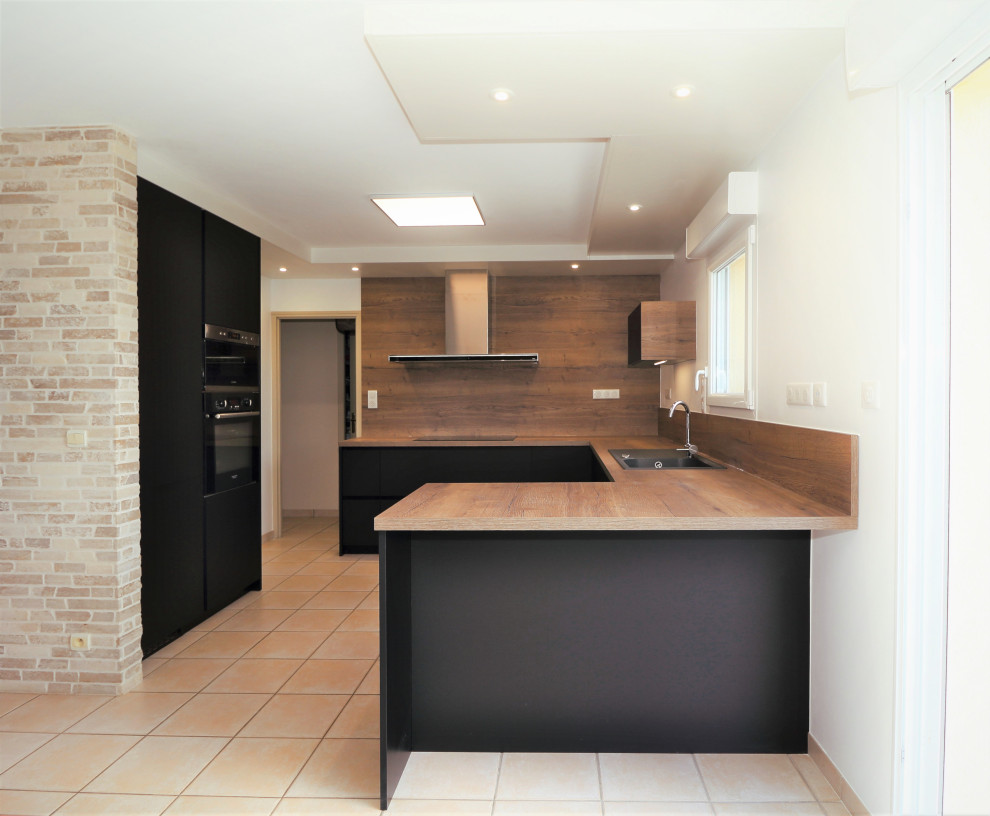 Exempel på ett stort modernt brun brunt kök, med klinkergolv i terrakotta, beiget golv, en undermonterad diskho, släta luckor, svarta skåp, laminatbänkskiva, brunt stänkskydd, stänkskydd i trä, integrerade vitvaror och en köksö