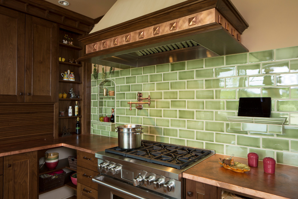 Inspiration for a traditional l-shaped separate kitchen in Portland with an undermount sink, recessed-panel cabinets, medium wood cabinets, copper benchtops, green splashback, subway tile splashback and panelled appliances.