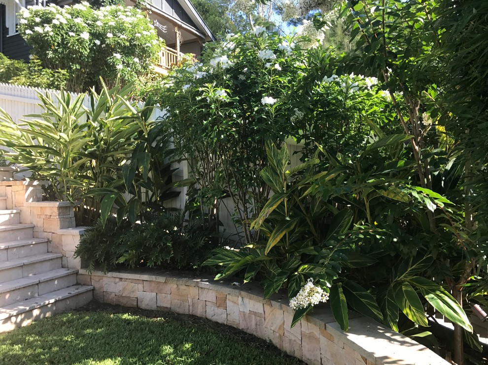 Immagine di un grande giardino formale tradizionale esposto a mezz'ombra davanti casa in estate con un ingresso o sentiero e pavimentazioni in pietra naturale