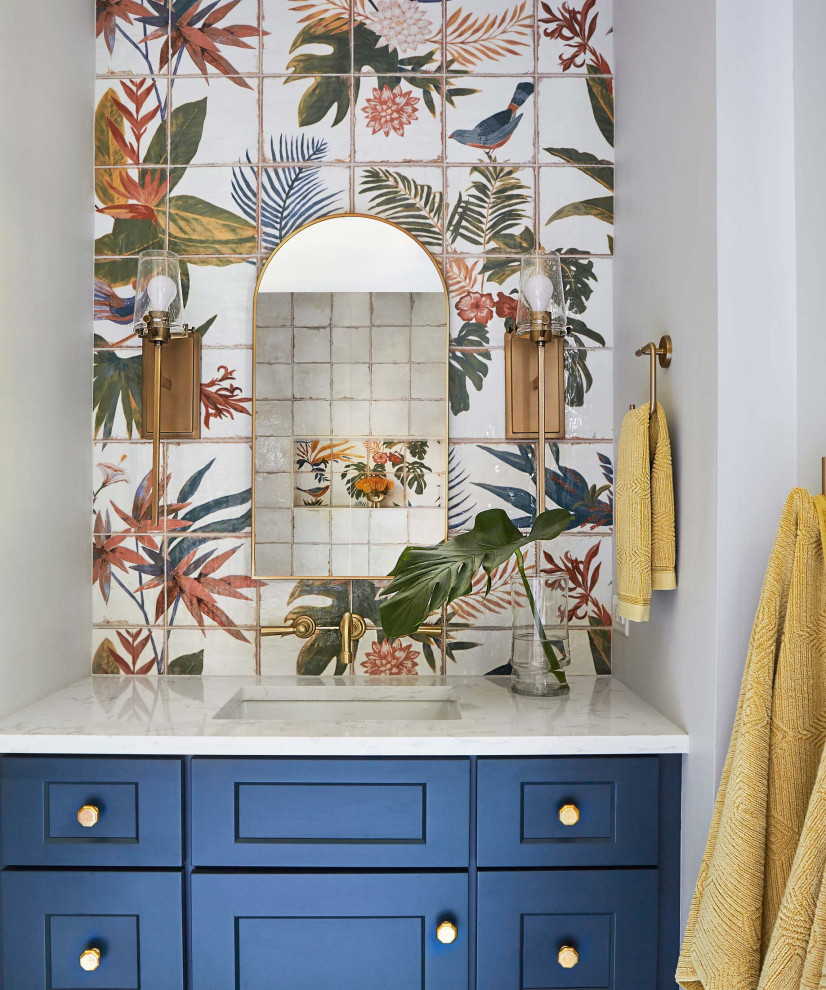 Photo of a medium sized world-inspired ensuite bathroom in Other with beaded cabinets, blue cabinets, a built-in bath, a shower/bath combination, white tiles, ceramic tiles, multi-coloured walls, mosaic tile flooring, a built-in sink, marble worktops, multi-coloured floors, a shower curtain, white worktops, a single sink, a freestanding vanity unit and wallpapered walls.