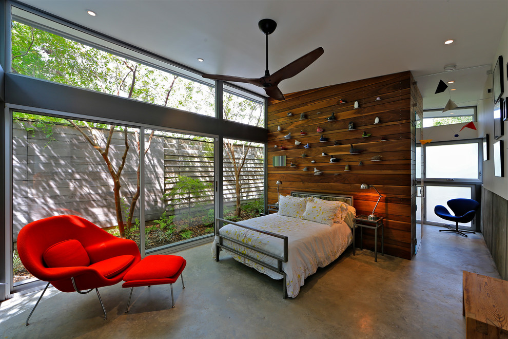 This is an example of a small contemporary master bedroom in Houston with concrete floors.