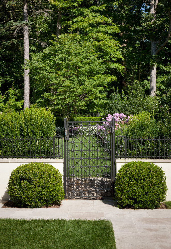 На фото: участок и сад на переднем дворе в средиземноморском стиле с покрытием из каменной брусчатки и забором с