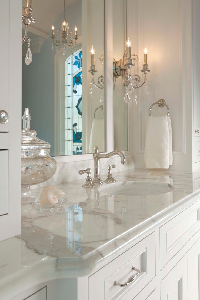 This is an example of a large traditional master bathroom in Houston with recessed-panel cabinets, white cabinets, a claw-foot tub, an alcove shower, blue walls, marble floors, an undermount sink, marble benchtops, white floor, a hinged shower door, white benchtops, a double vanity, a built-in vanity and panelled walls.