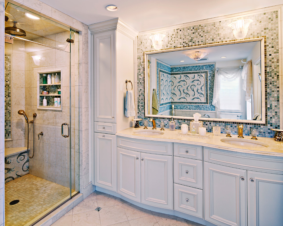 This is an example of a large beach style master bathroom in New York with white cabinets, an undermount sink, solid surface benchtops, recessed-panel cabinets, an alcove shower, beige tile, ceramic tile, multi-coloured walls and ceramic floors.