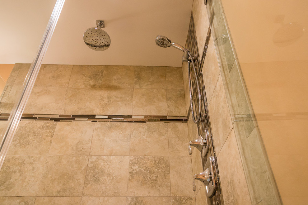 This is an example of a mid-sized arts and crafts master bathroom in Other with shaker cabinets, medium wood cabinets, ceramic floors, an alcove shower, beige tile, ceramic tile, orange walls, a wall-mount sink, engineered quartz benchtops, brown floor, a hinged shower door and white benchtops.