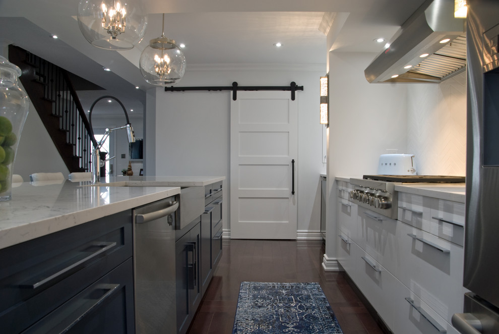 Eat-in kitchen - mid-sized transitional galley medium tone wood floor and brown floor eat-in kitchen idea with a farmhouse sink, glass-front cabinets, white cabinets, quartz countertops, white backsplash, ceramic backsplash, stainless steel appliances, an island and white countertops