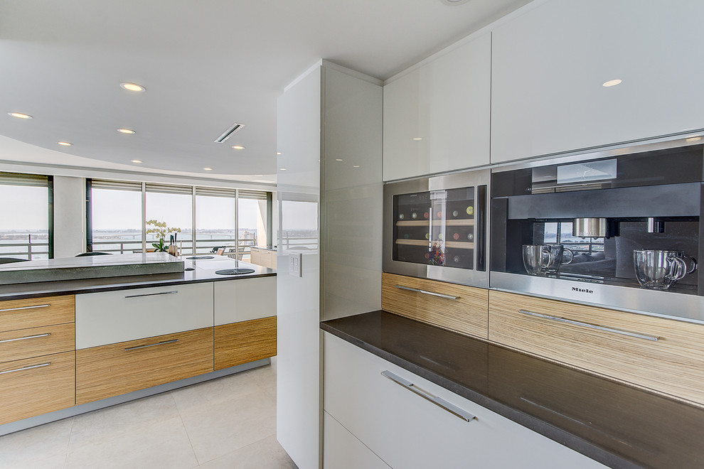 Design ideas for a large modern l-shaped open plan kitchen in Other with an undermount sink, flat-panel cabinets, white cabinets, concrete benchtops, grey splashback, panelled appliances, porcelain floors, with island, grey floor and grey benchtop.