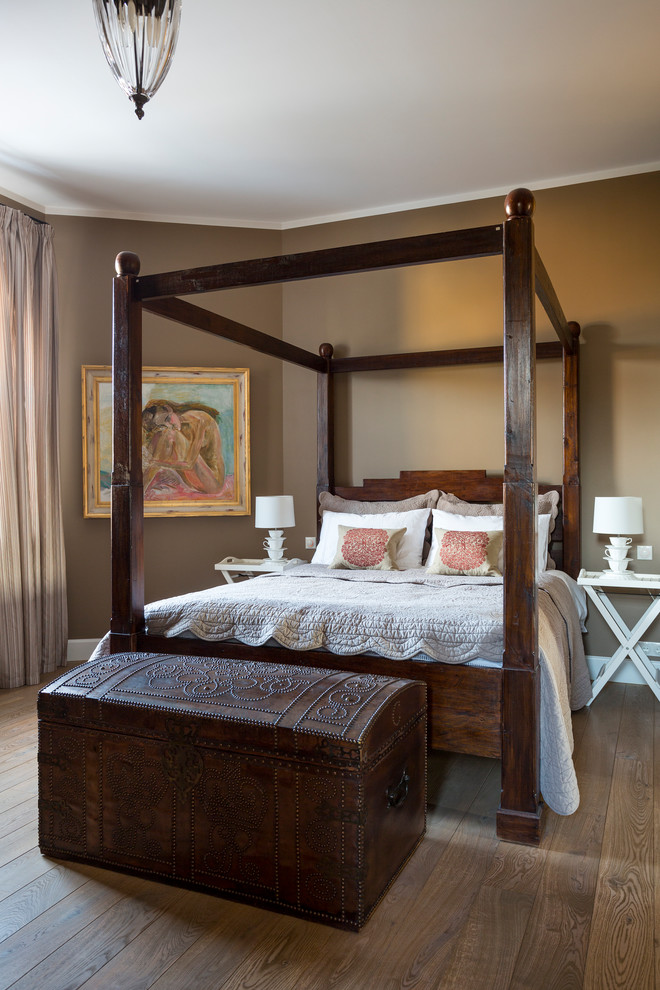 Inspiration for a mediterranean bedroom in London with brown walls, medium hardwood floors and brown floor.