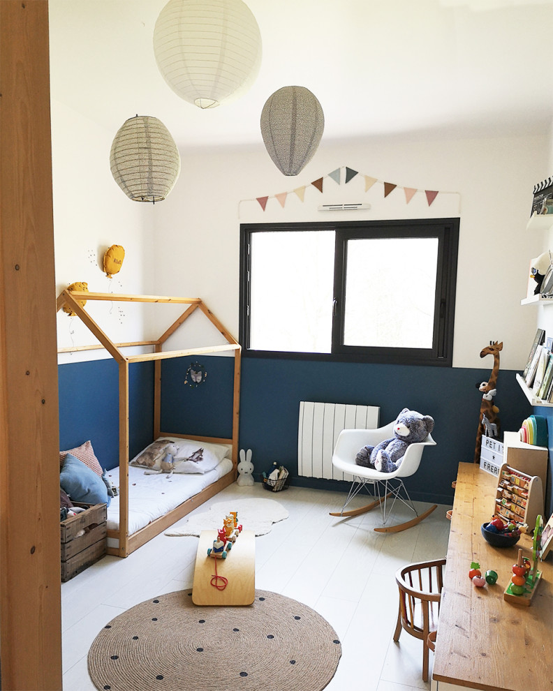 На фото: детская в скандинавском стиле с спальным местом, синими стенами, полом из ламината и белым полом для ребенка от 1 до 3 лет, мальчика