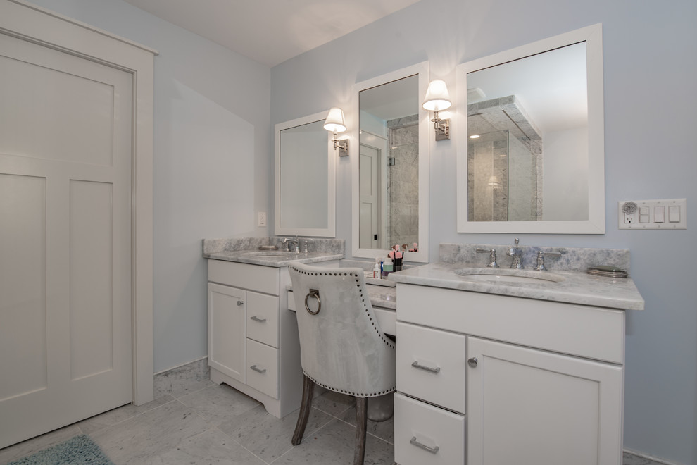 Photo of a mid-sized traditional master bathroom in New York with recessed-panel cabinets, white cabinets, blue walls, an undermount sink, granite benchtops, grey floor, multi-coloured benchtops, a freestanding tub, an alcove shower, a two-piece toilet, marble, ceramic floors and a hinged shower door.