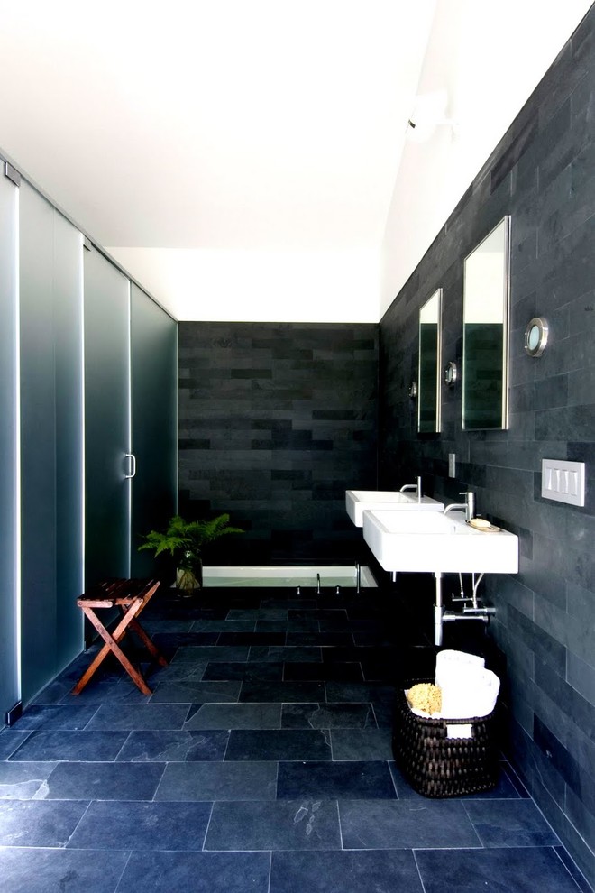 Photo of a contemporary bathroom in New York with a wall-mount sink, black walls, slate floors and slate.