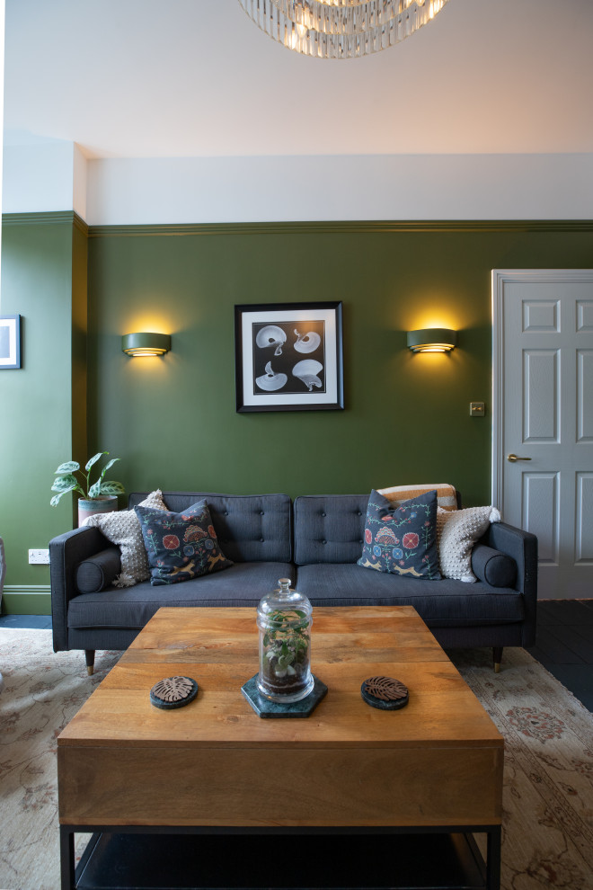 Photo of a medium sized contemporary enclosed living room in London with a reading nook, green walls, a freestanding tv and feature lighting.