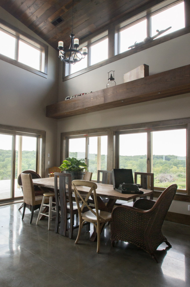 Photo of a rustic kitchen/dining room in Cedar Rapids with concrete flooring, grey floors and a vaulted ceiling.