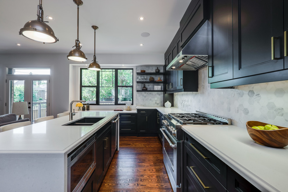Photo of a mid-sized transitional l-shaped open plan kitchen in Toronto with a double-bowl sink, solid surface benchtops, grey splashback, stainless steel appliances, with island, recessed-panel cabinets and medium hardwood floors.
